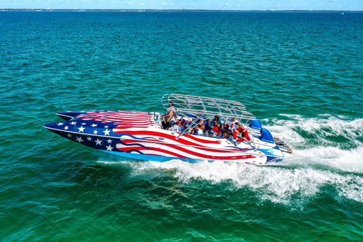 Speedboat with American flag design on blue ocean water.